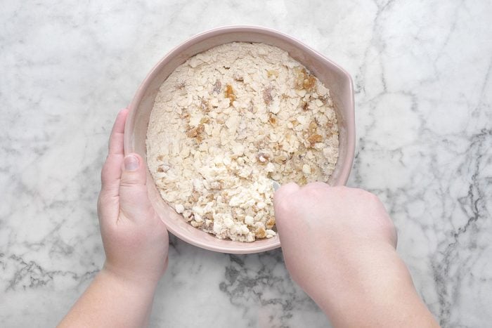 Flour, brown sugar, chopped walnuts mixed inside a bowl