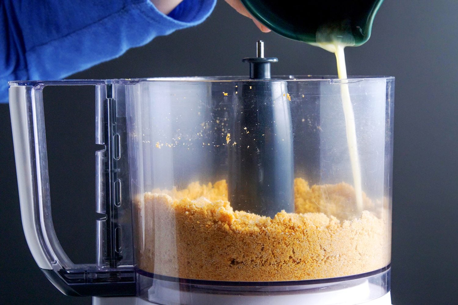Melted butter being adder in the mixture of Cannoli shells in a food processor