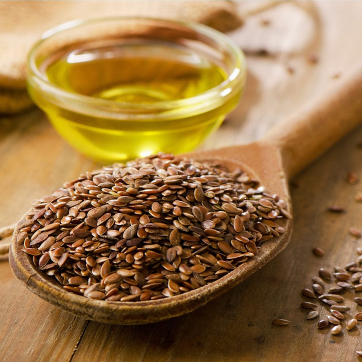 Brown flax seeds on a spoon and flaxseed oil