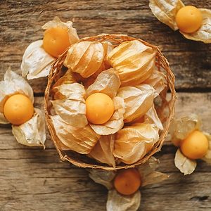 Husk tomato and Ground Cherry in basket on wood table background.