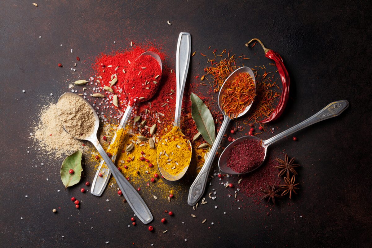 Various spices spoons on stone table.