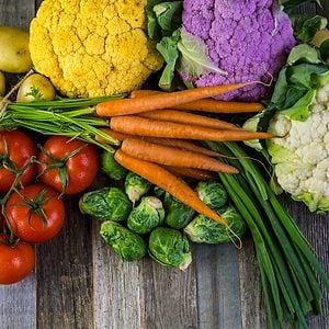Fresh organic vegetable in season on old farm table.