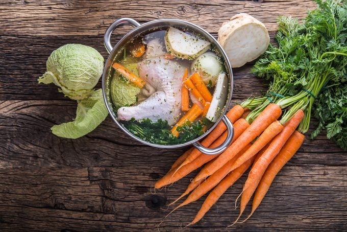 Top view of chicken soup - broth on wooden table