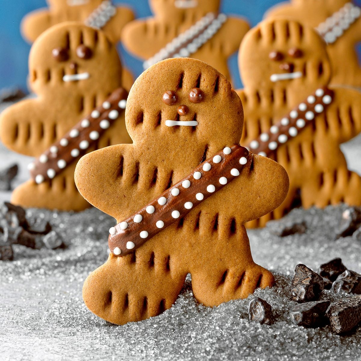 Wookiee Cookies; Low camera angle; cutout cookies; shaped cookies; star wars; May the 4thbe with you; gray surface; Blue background; rock candy; snack; dessert; cookies; gingerbread; gingerbread man; chocolate chips