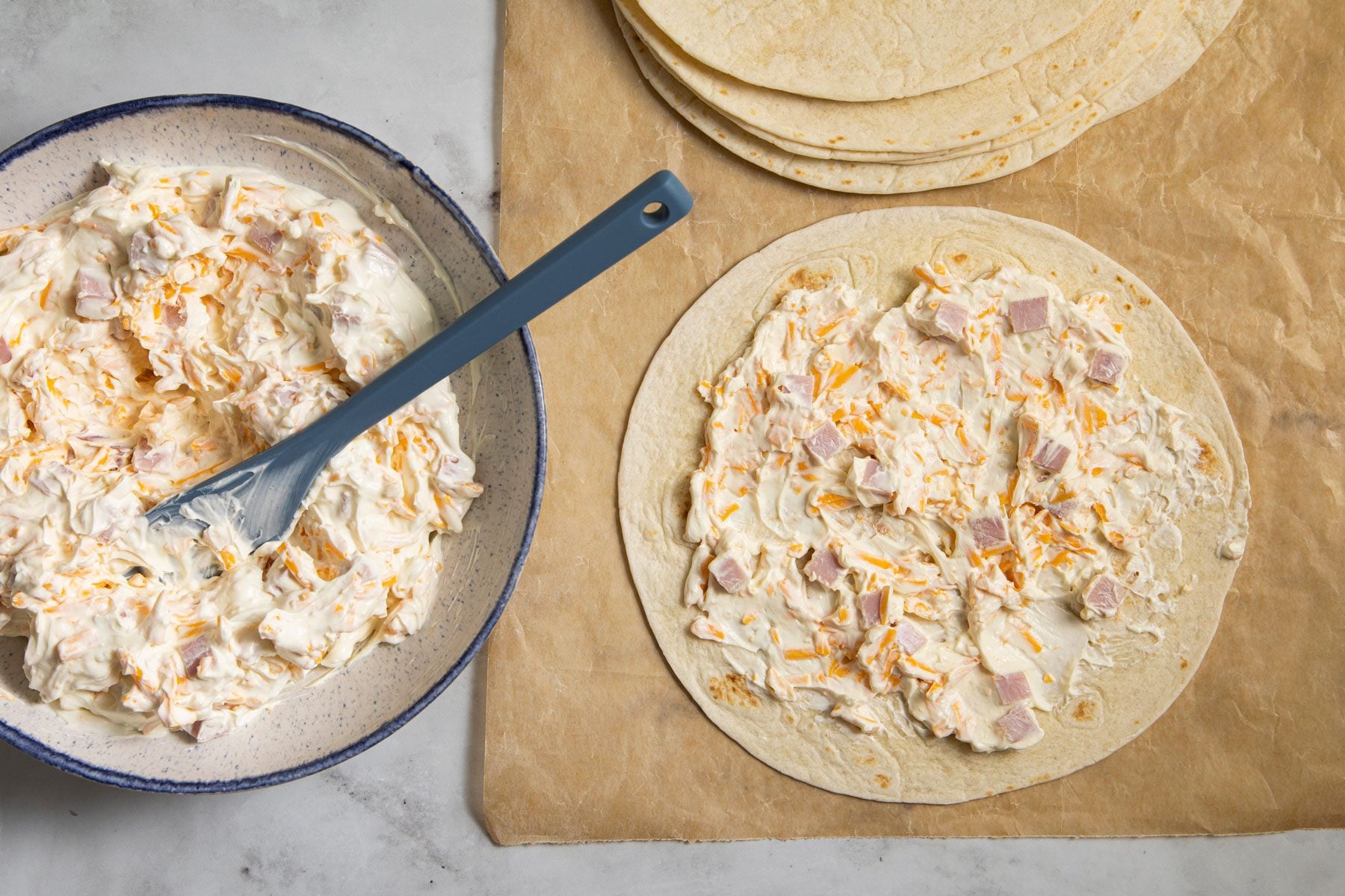 Ham And Cheese filling spread over the tortillas