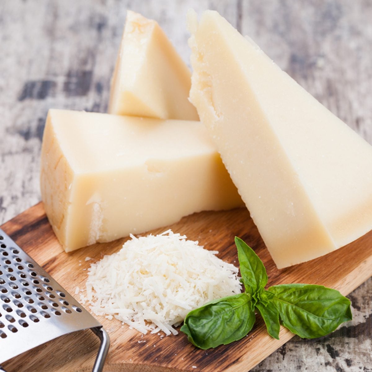 grated parmesan cheese and metal grater on wooden board