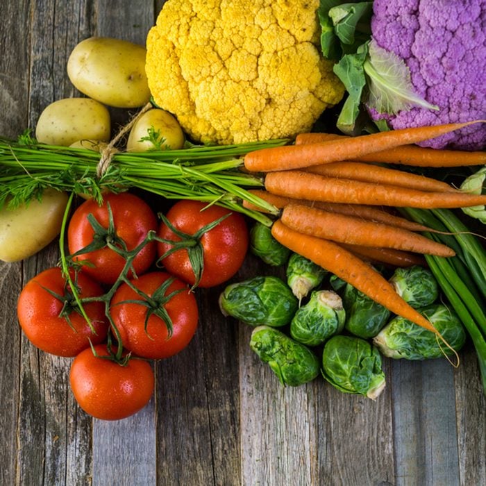 Fresh organic vegetable in season on old farm table.