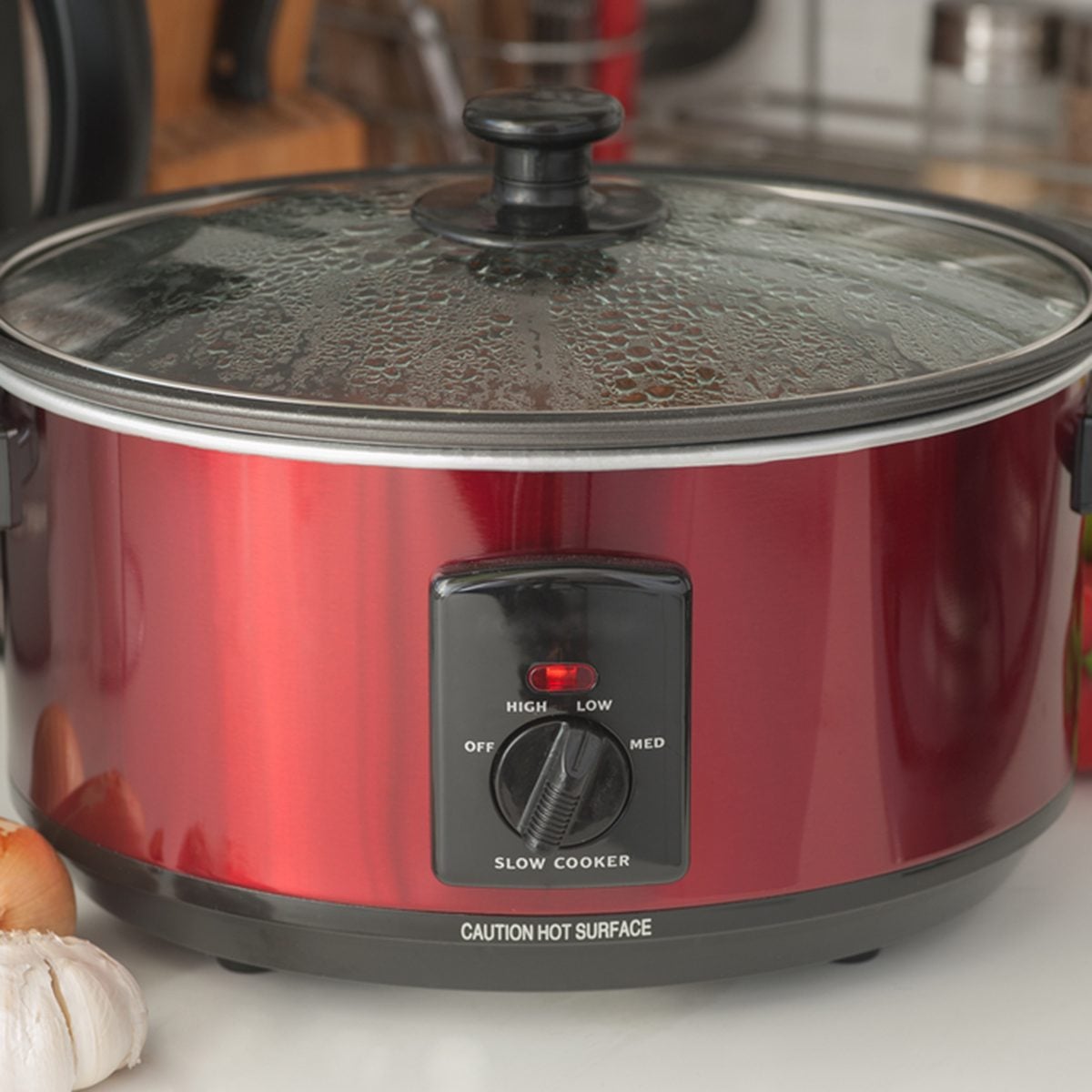 Close up of a slow cooker working on kitchen shelf