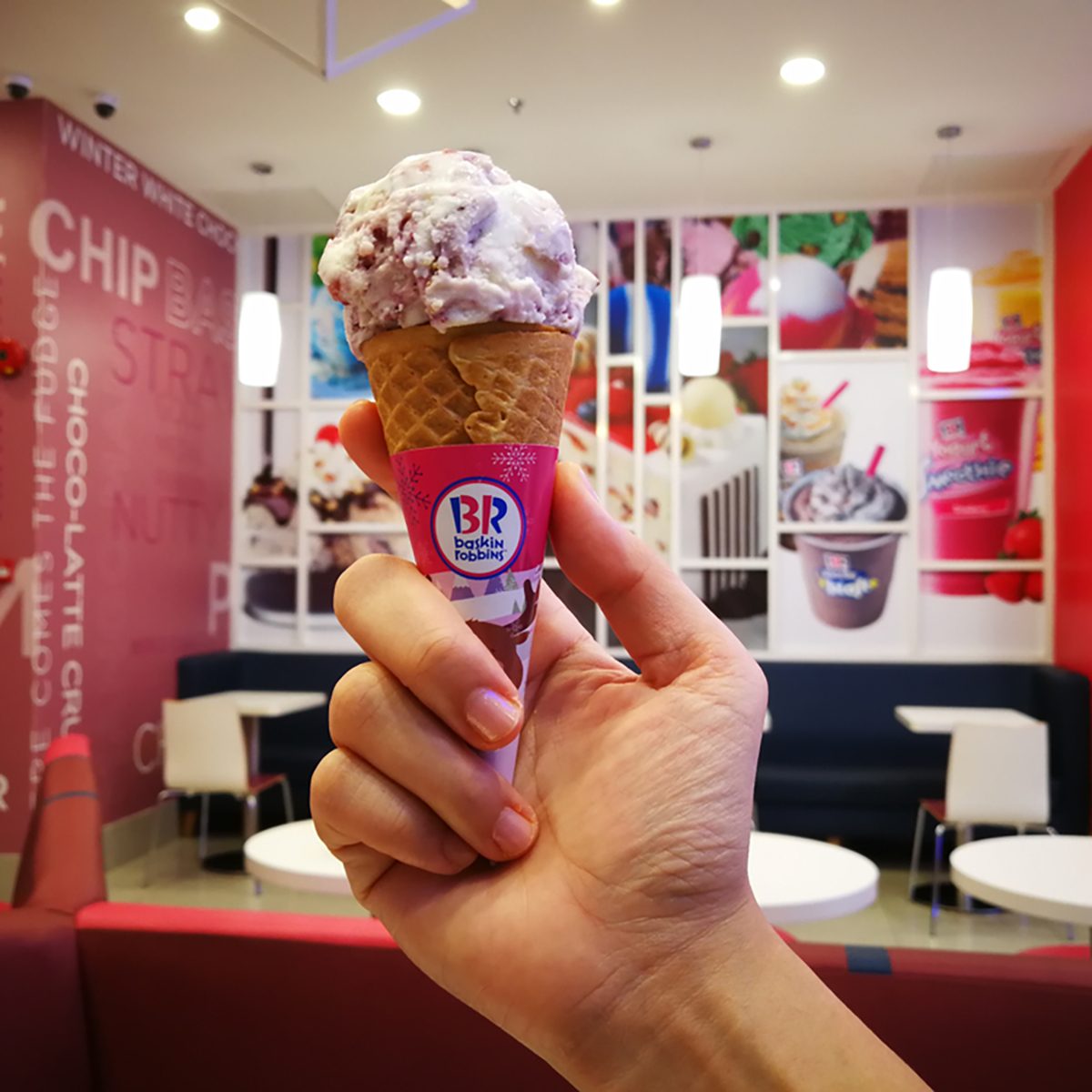 Hand holding Baskin Robbins ice cream cone. Baskin-Robbins is the world