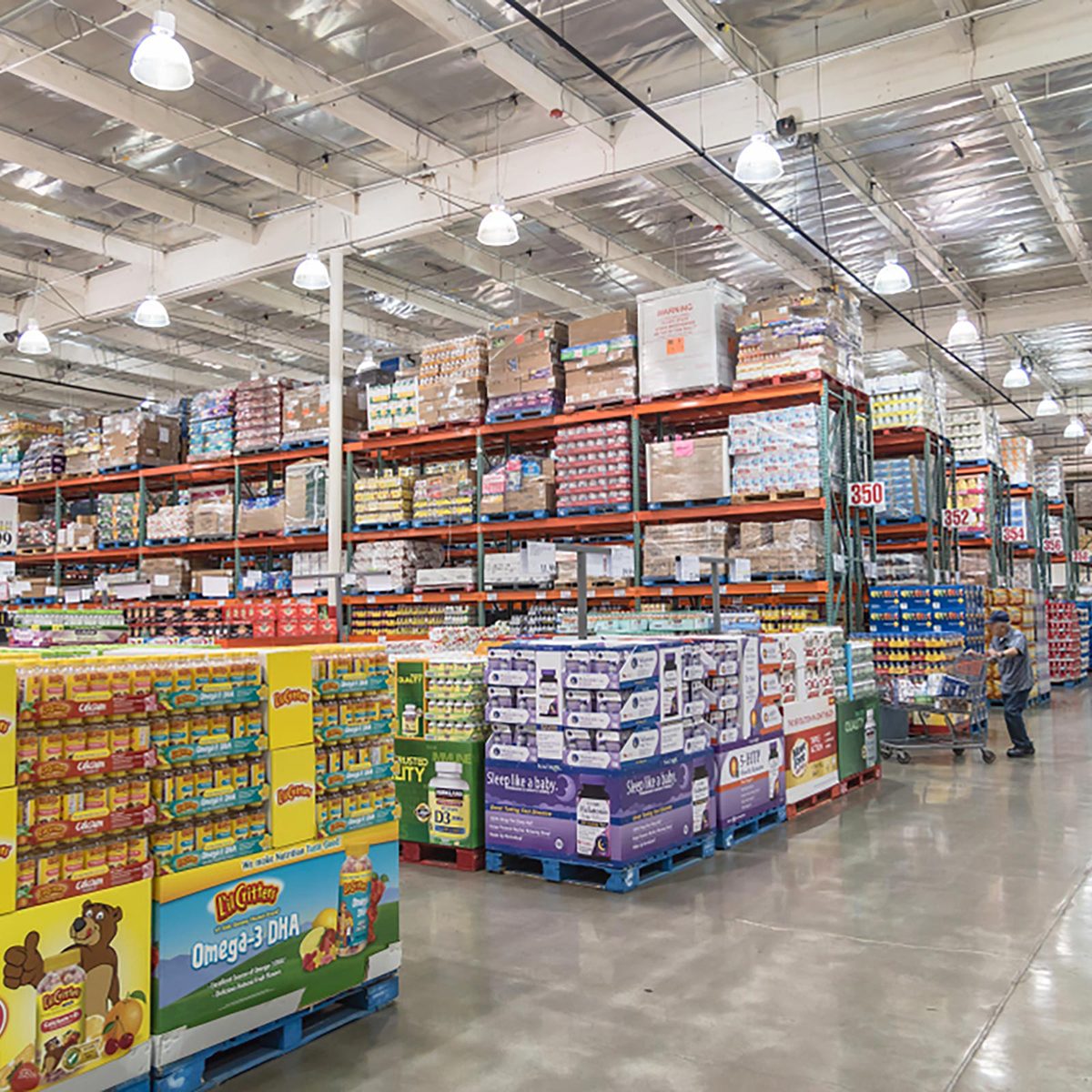 Customer shopping for supplements and multivitamin at Costco Wholesale big-boxes store.