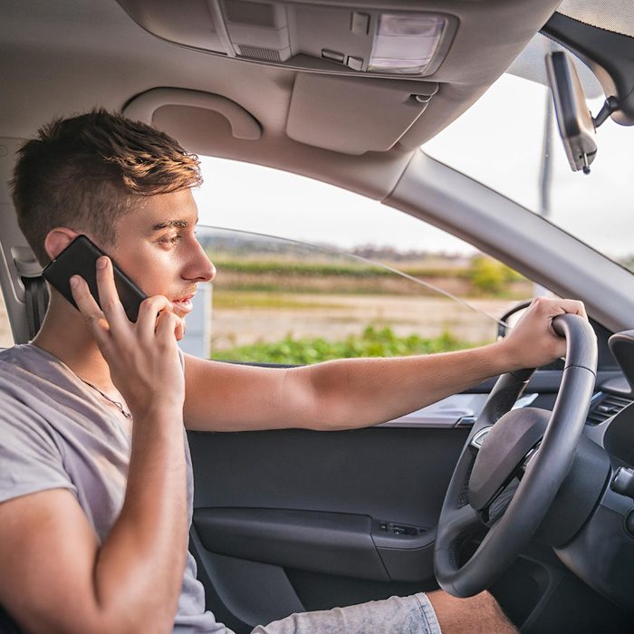 Kid driving car while on phone