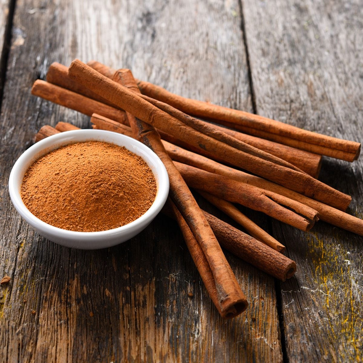 Cinnamon sticks and cinnamon powder on wood