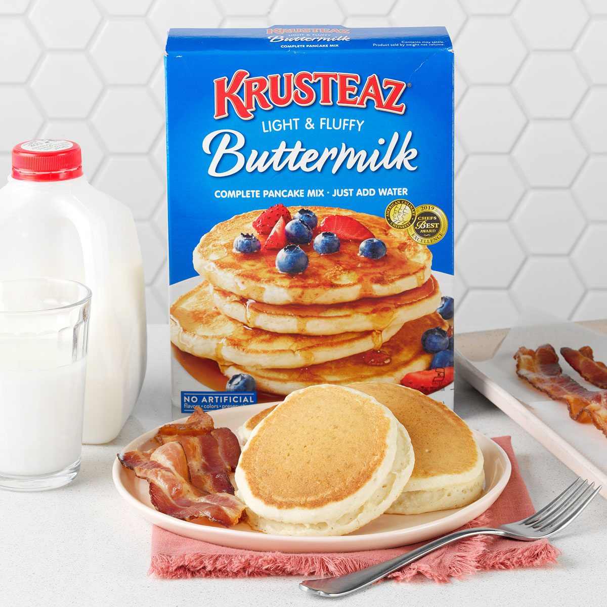 Pancakes, pancake pre mix box, bacons and milk in the glass