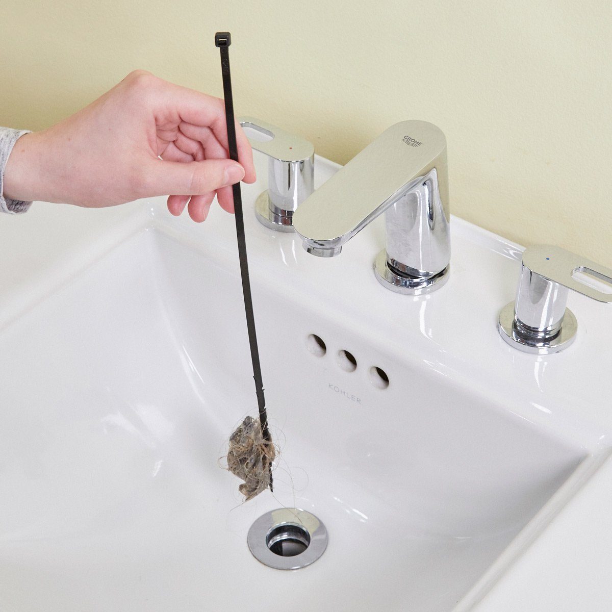 Using a zip-tie to pull up a clog from a drain