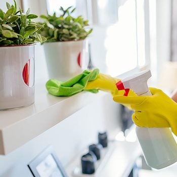 Woman wearing yellow rubber protective gloves and cleaning white shelf.; Shutterstock ID 546648745; Job (TFH, TOH, RD, BNB, CWM, CM): Taste of Home