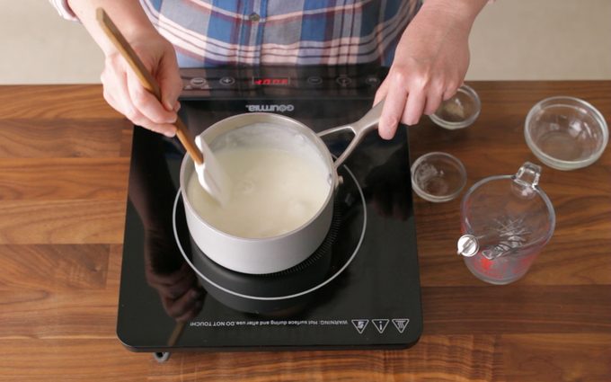 person stirring gravy with a rubber spatula