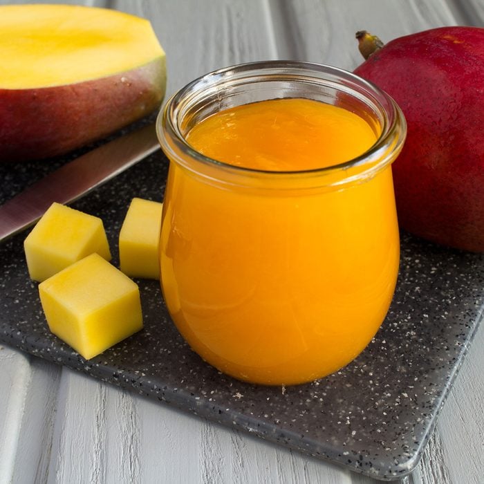 Puree with mango and ingredient on the grey cutting board