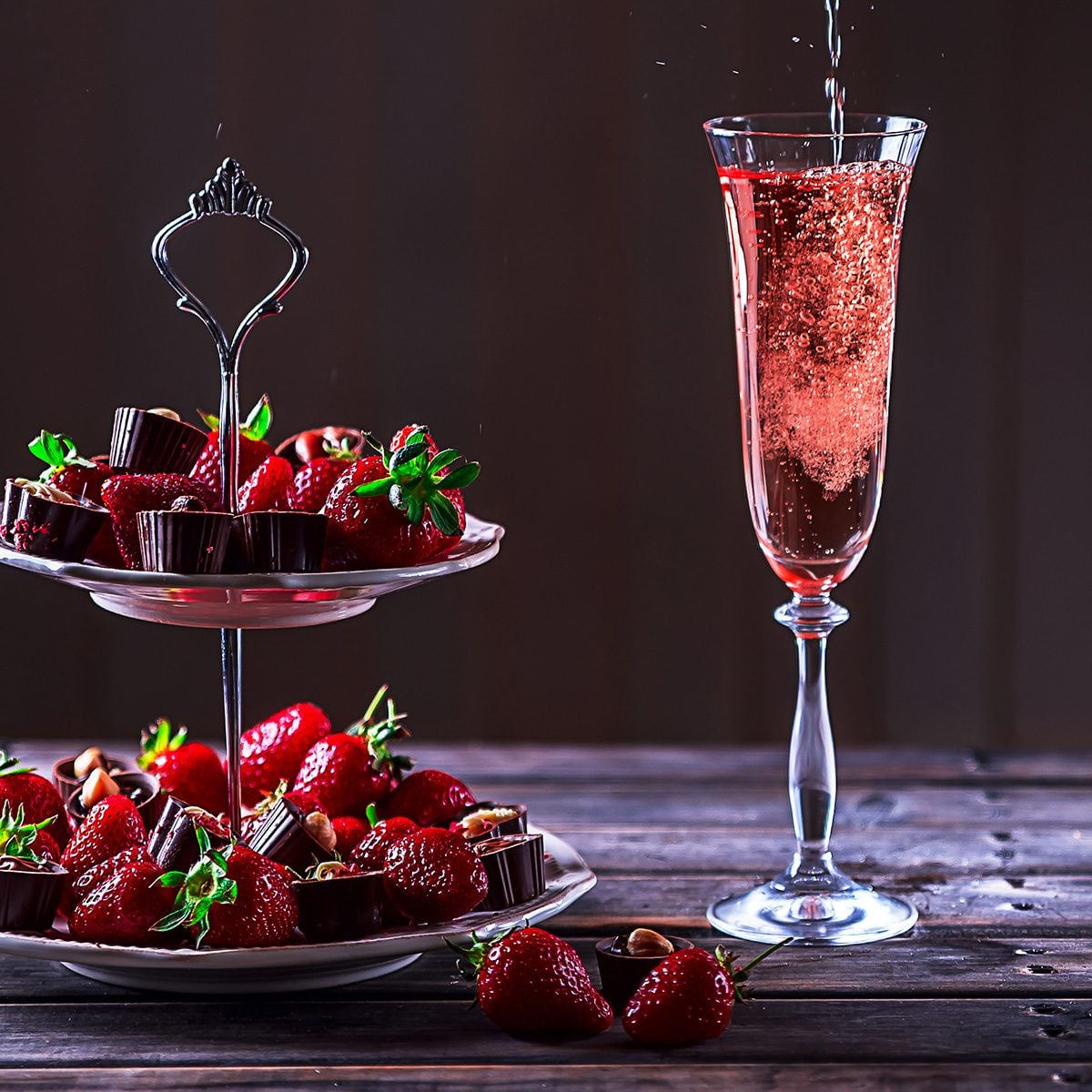 Sparkling pink wine is poured in glass.