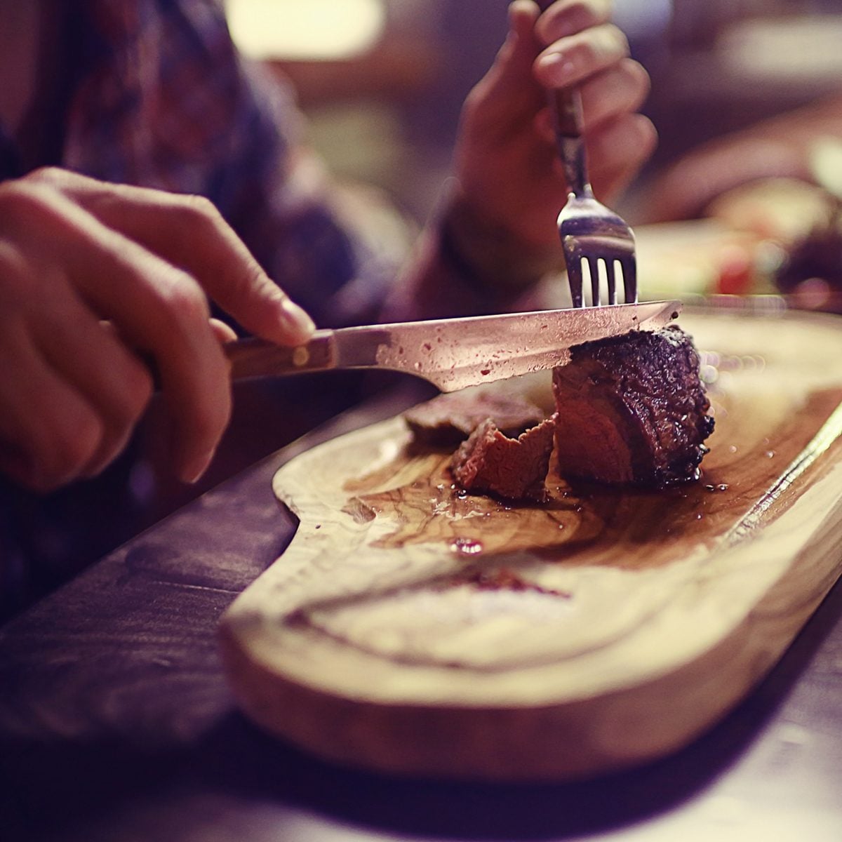 steak in the restaurant on the table / dinner in the restaurant, meat on the plate, served steak and cutlery