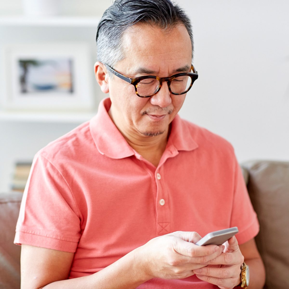 technology, people, lifestyle and communication concept - man with smartphone sitting on sofa at hom