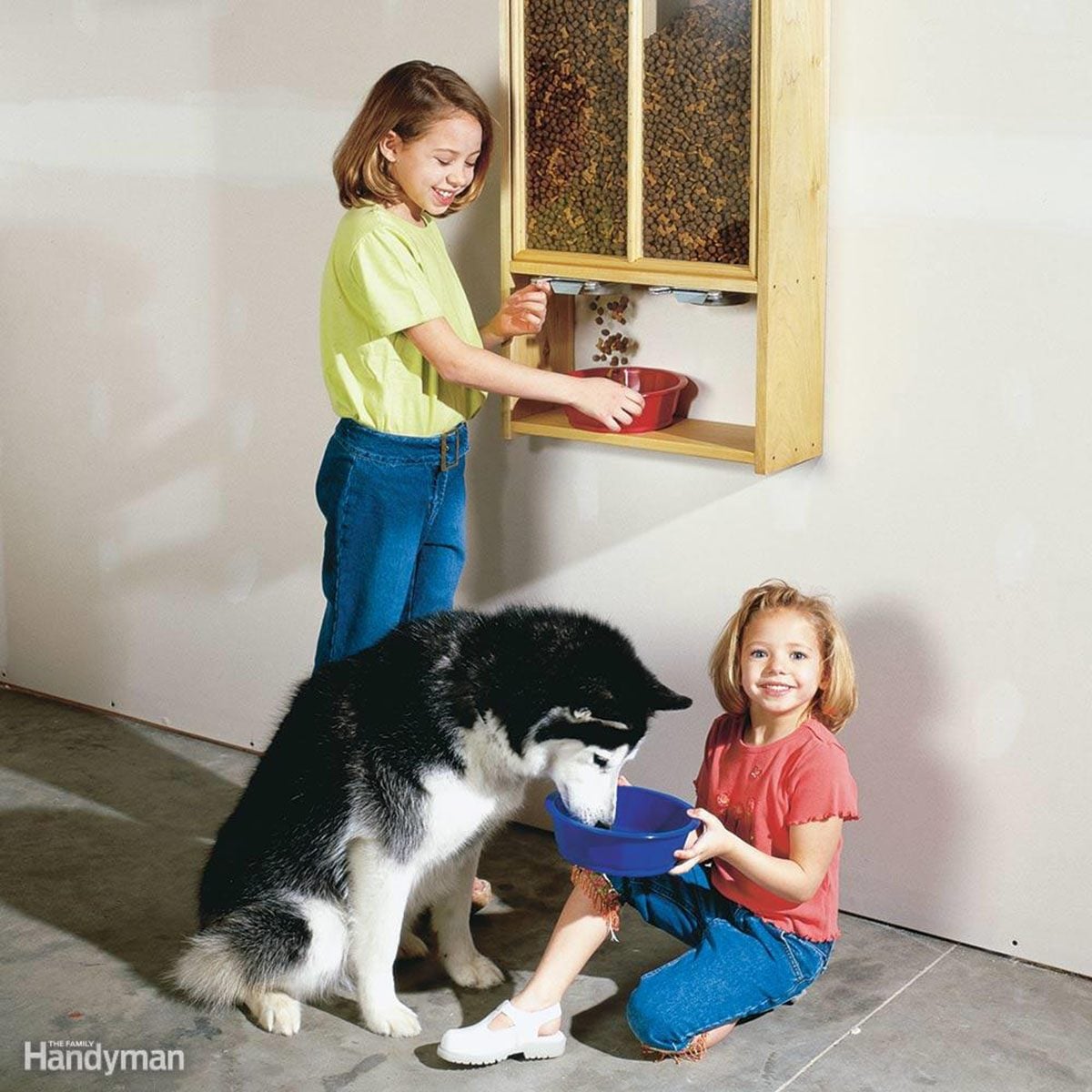 Two kids feeding husky