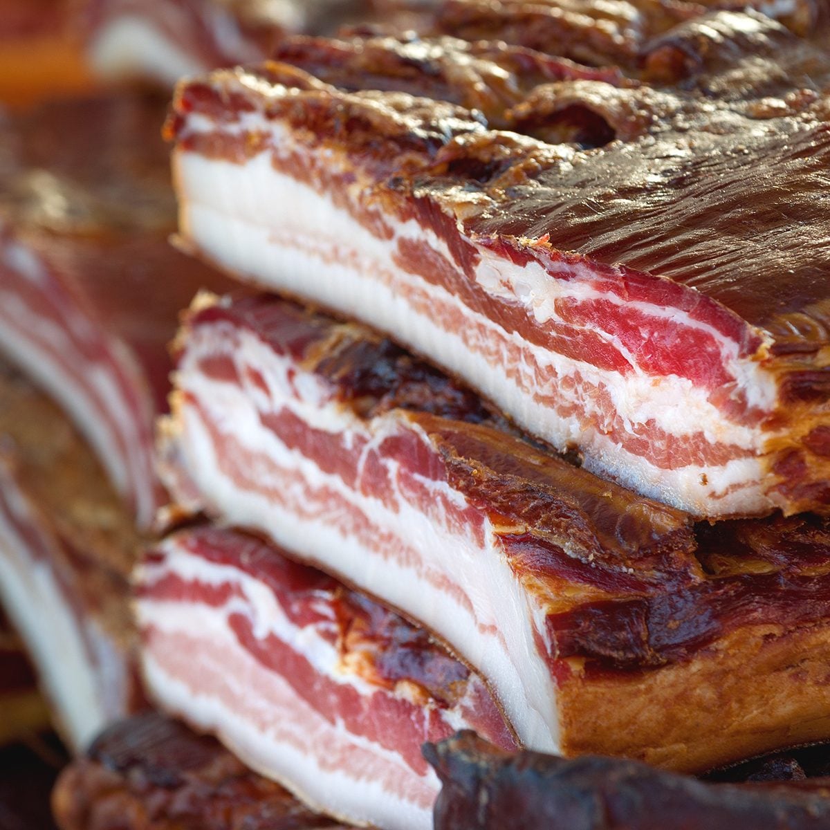 Cured Bacon Stack Selective Focus with Shallow deth of field, Smoked and Preserved Pork Meat is Considered a Delicacy Food in Some Cultures.