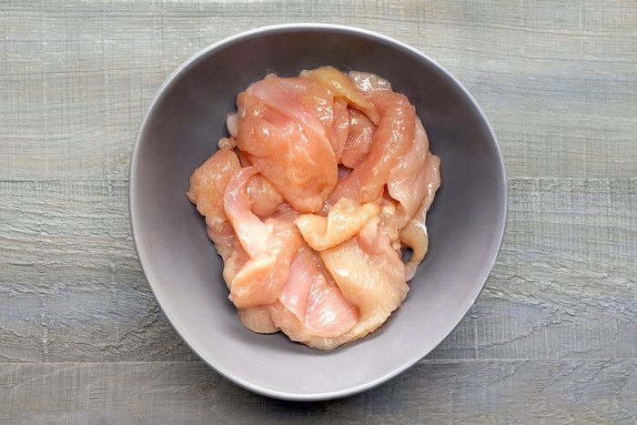 Mixing Chicken with Salt, Pepper and Oil in a Bowl