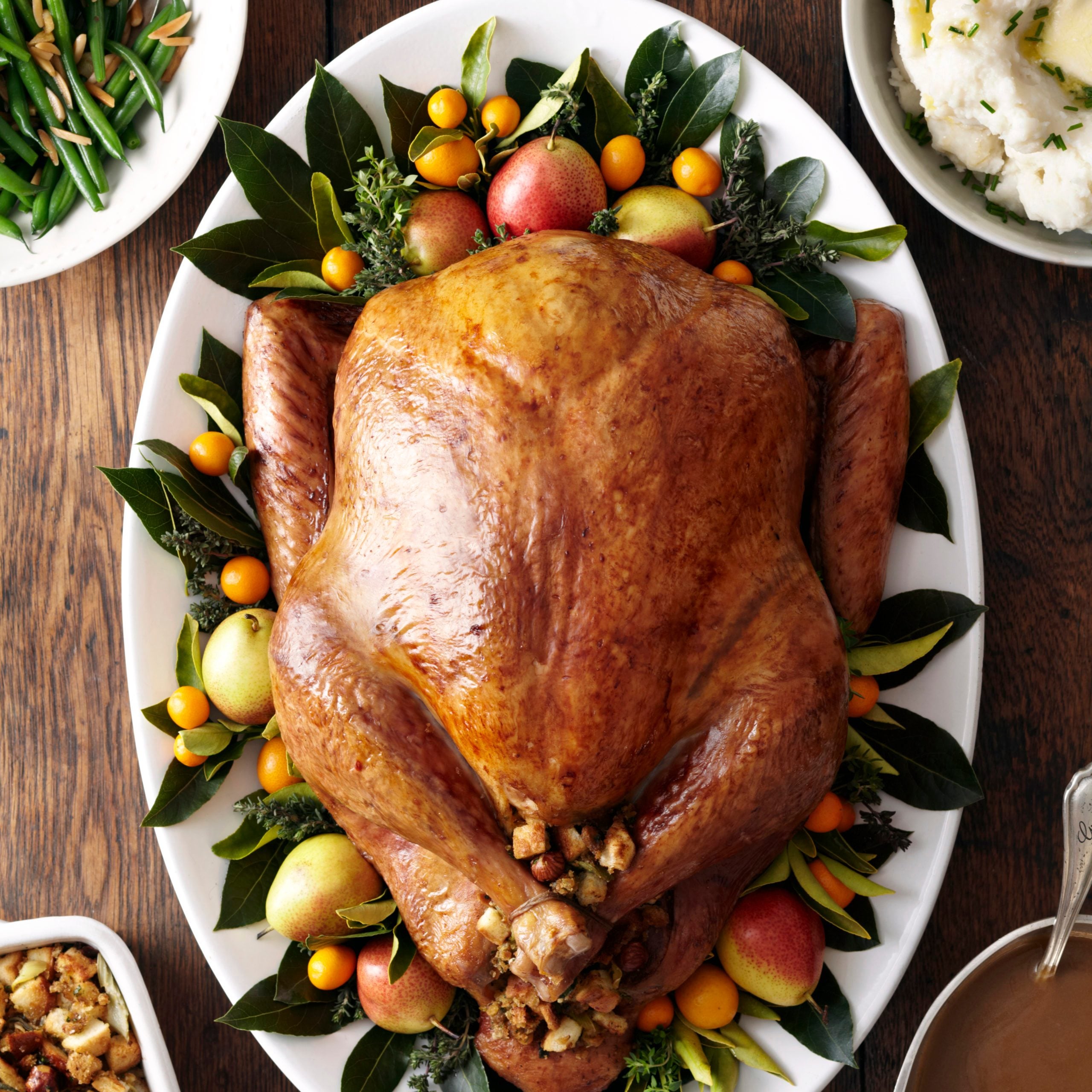 Turkey, stuffing, and gravy dishes on wood surface