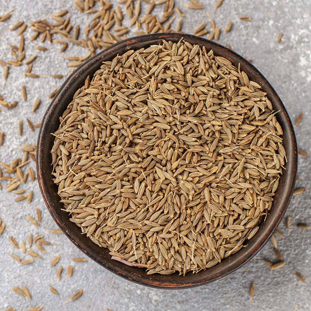 indian spices Cumin seeds (Zira) in a ceramic bowl close-up. Seasoning. Condiment. Selective focus. Top view and copy space