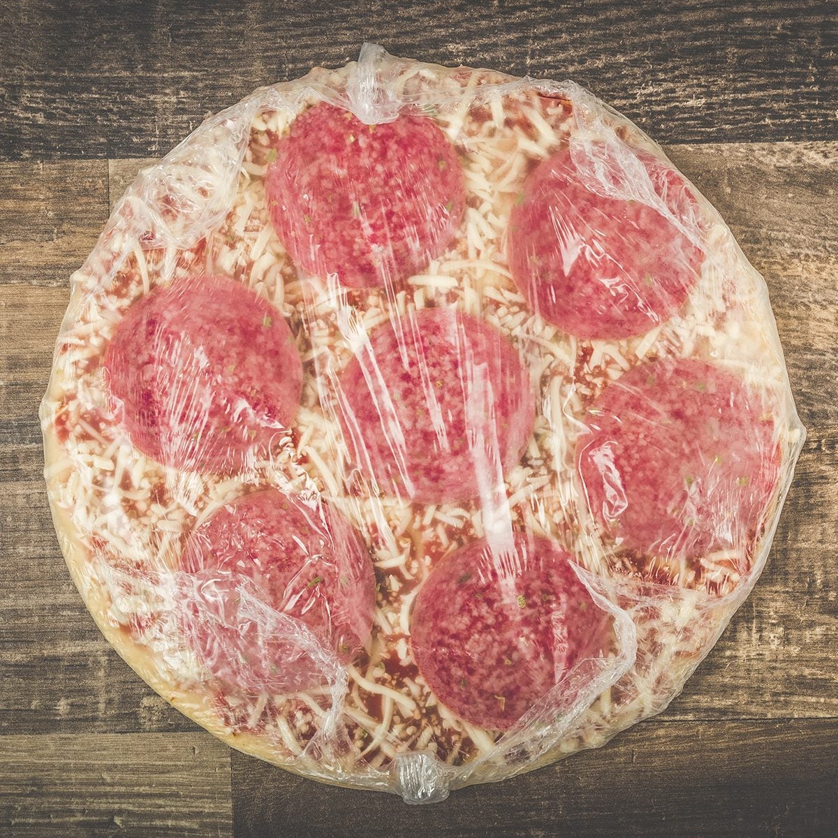 Delicious Mouth Watering Raw Frozen Pizza On A Kitchen Table