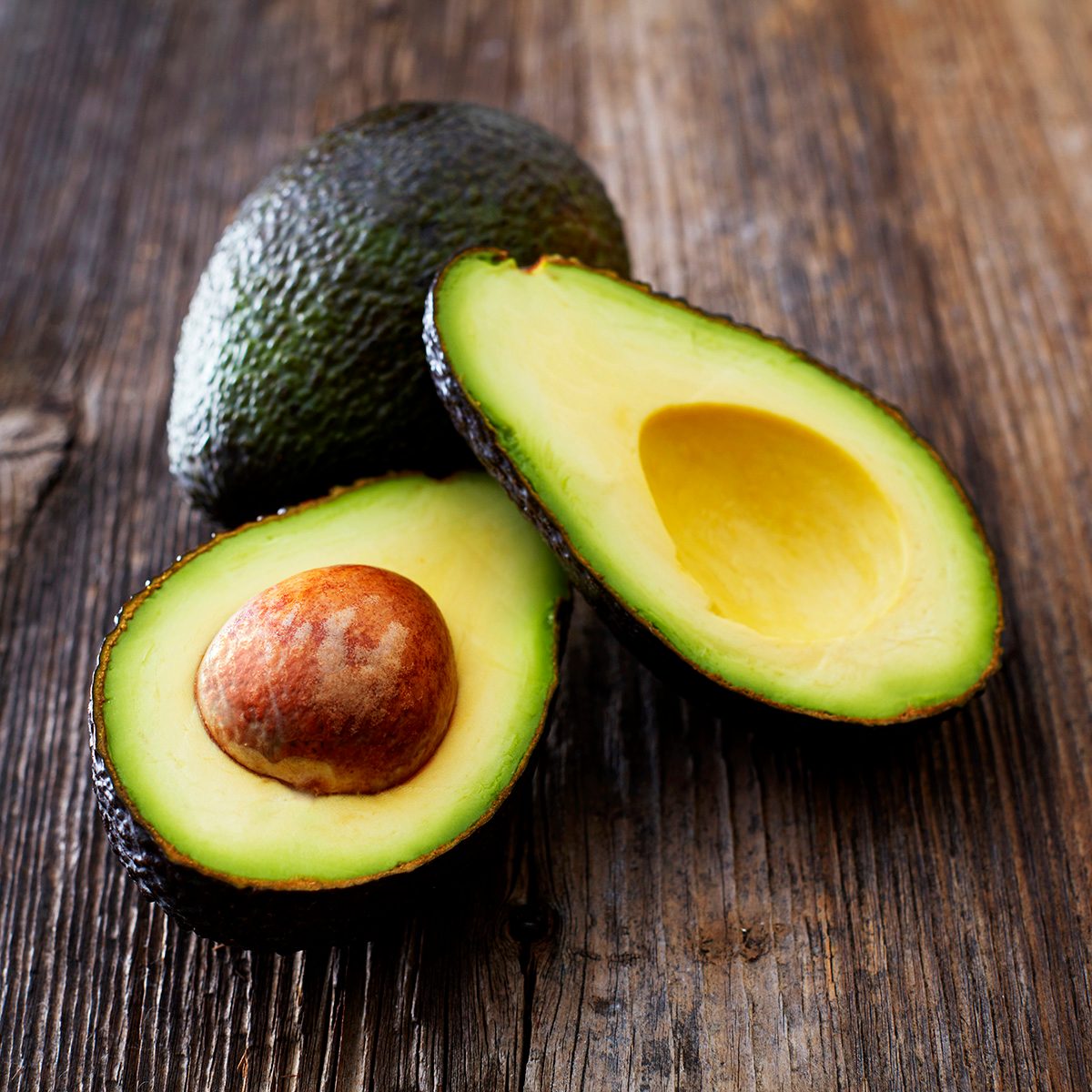 Whole And Sliced Avocado On Wood