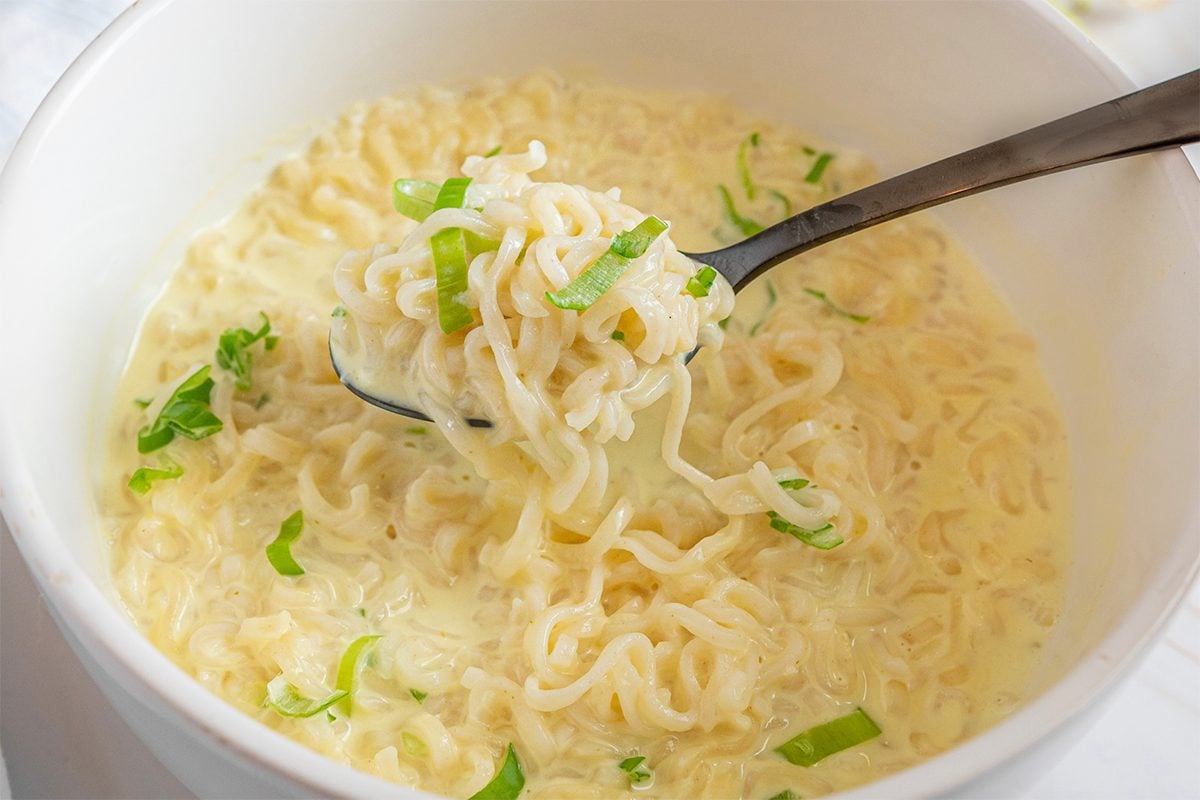 Spoon Lifting Creamy Ramen Out Of A Bowl