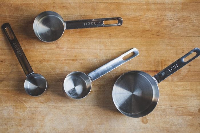 Overhead view of various measuring cups on wooden table