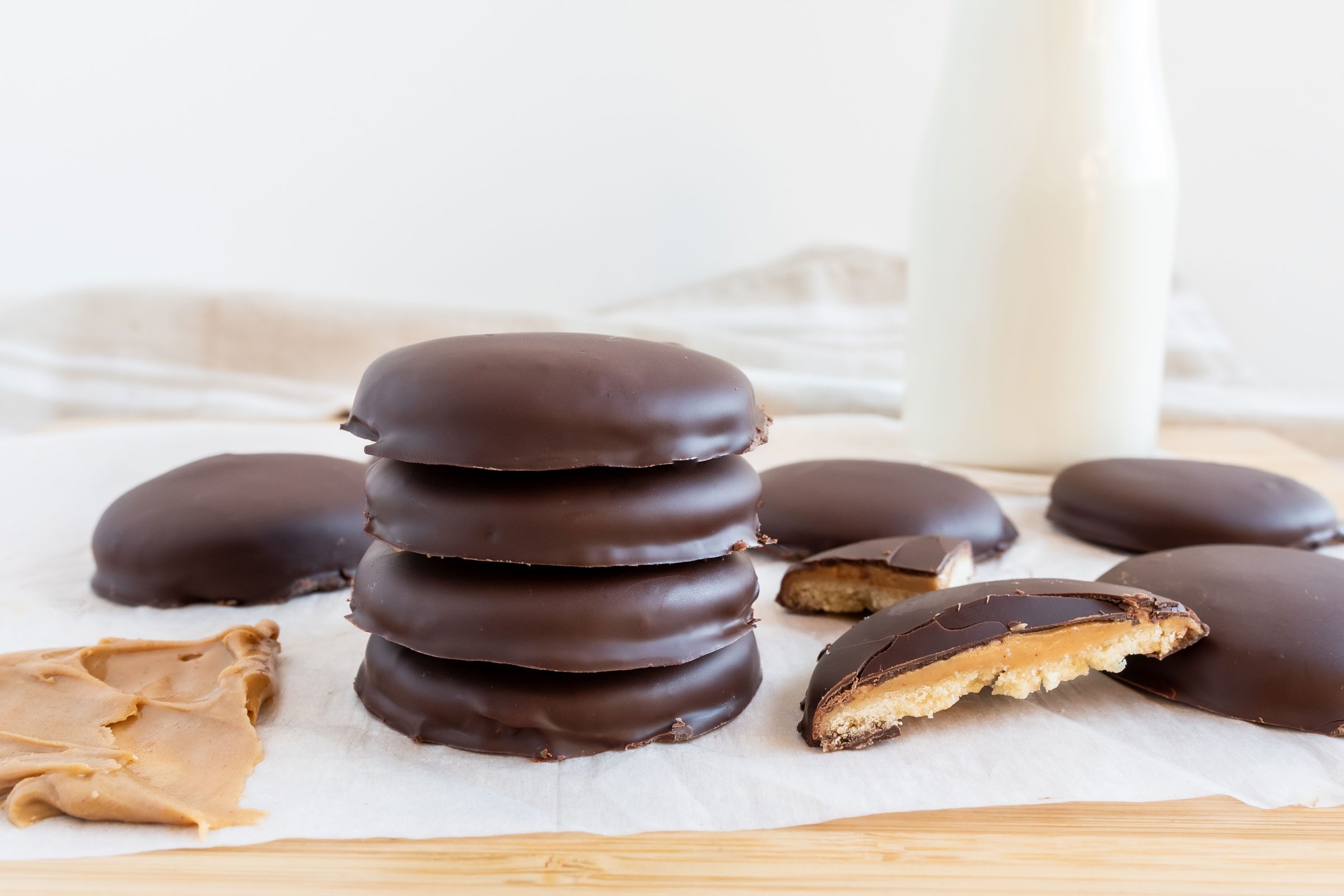Tagalongs finished cookies; stacked near a glass of milk