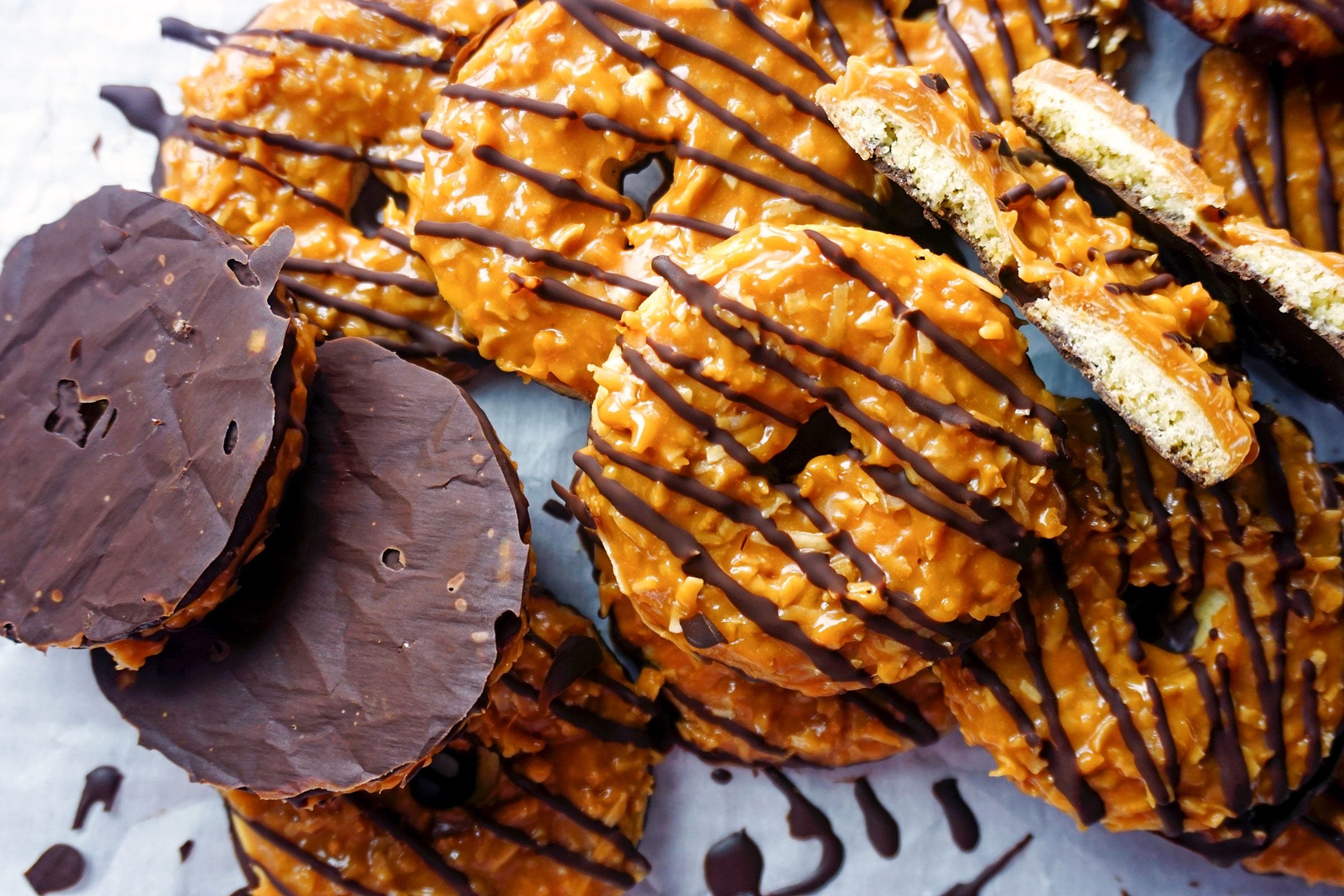 close up of a bunch of homemade girl scout samoa cookies on a sheet of wax paper