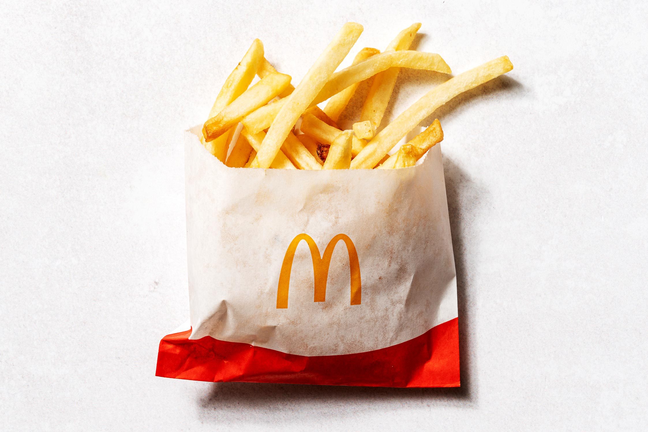 KFC fries in a cardboard cup that says kentucky fried chicken secret recipe fries