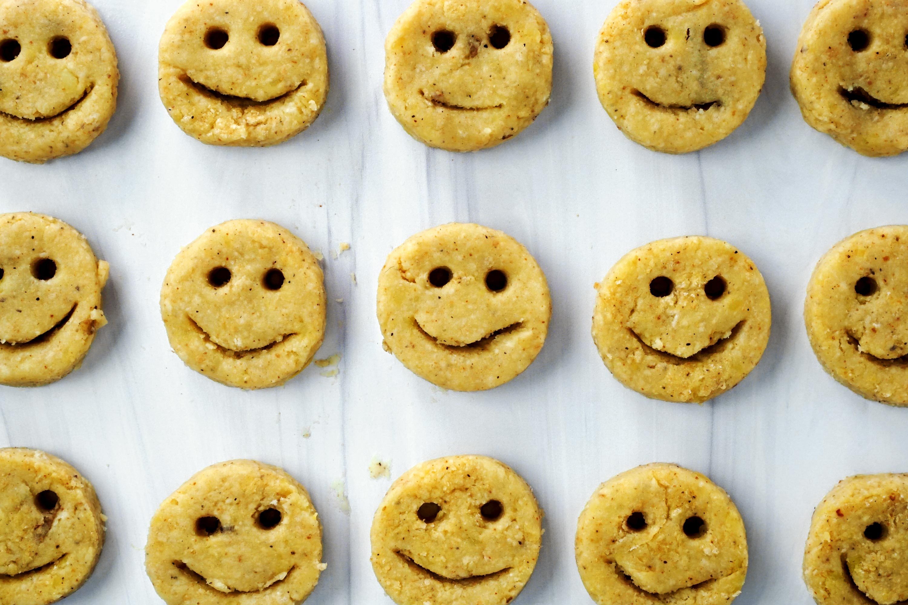 an orderly grid of raw potato smileys before getting fried or baked, view from above