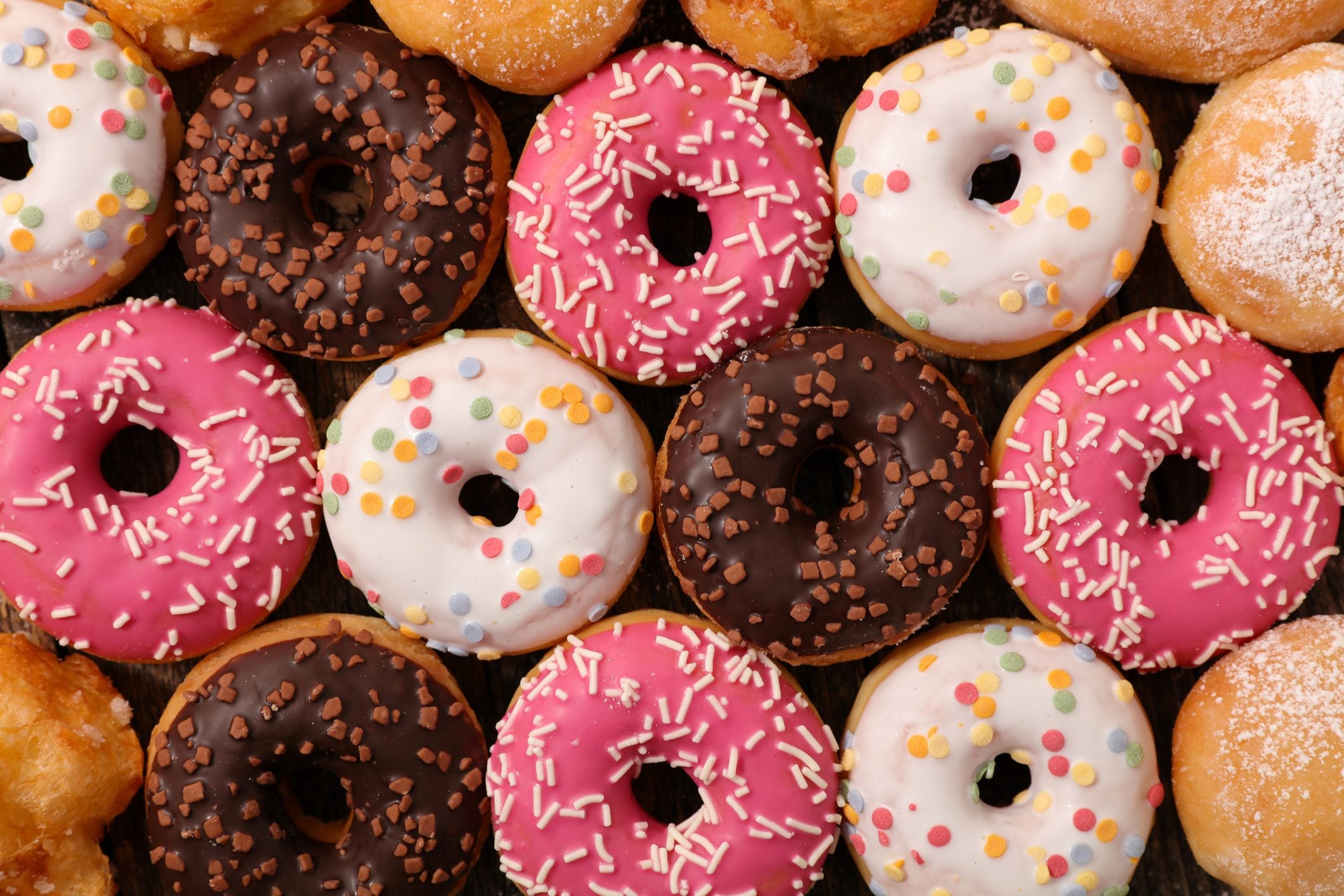 full frame of assorted glazed donut with different kinds of frosting