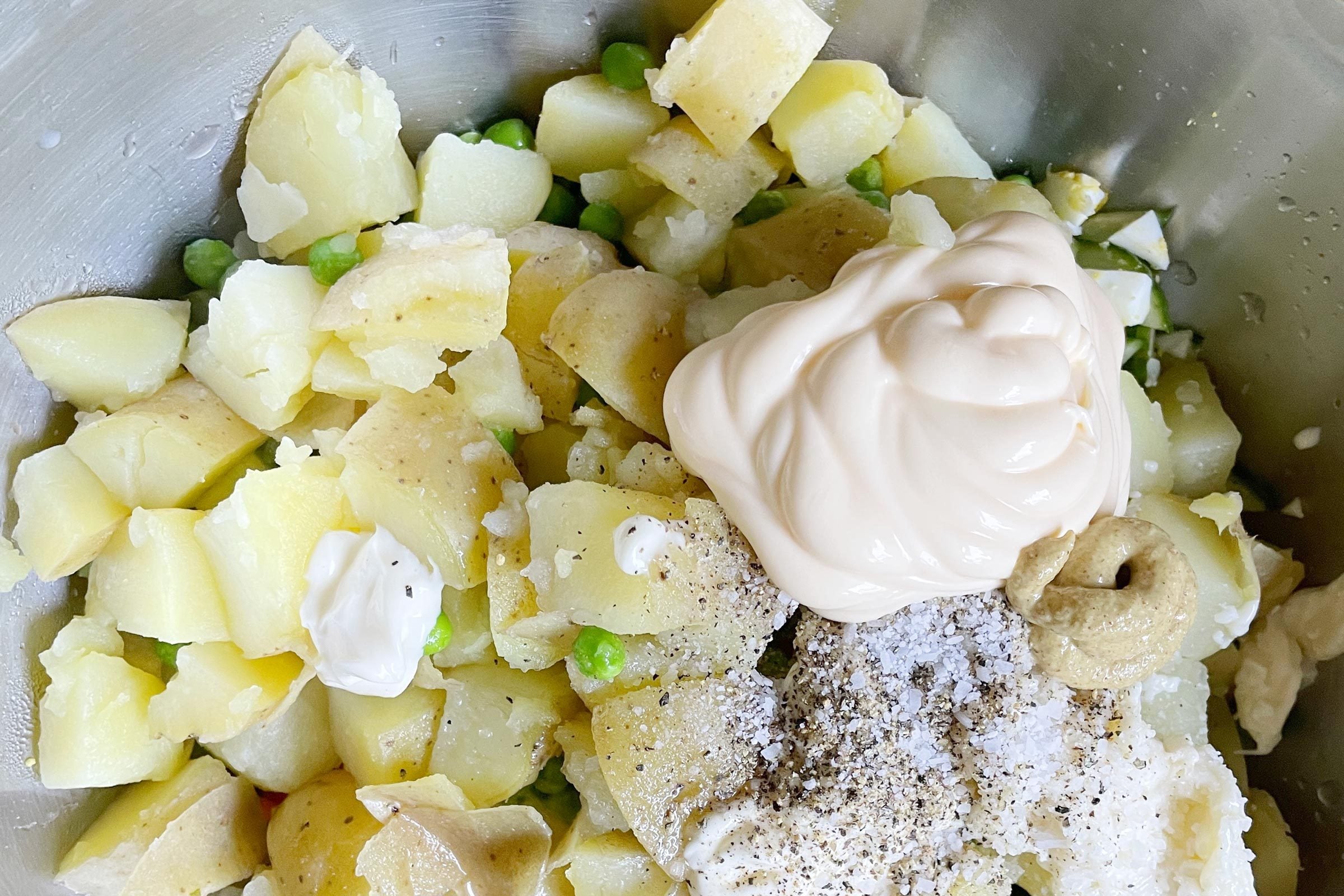 close up of unmixed ingredients in a bowl for making Hawaiian potato salad