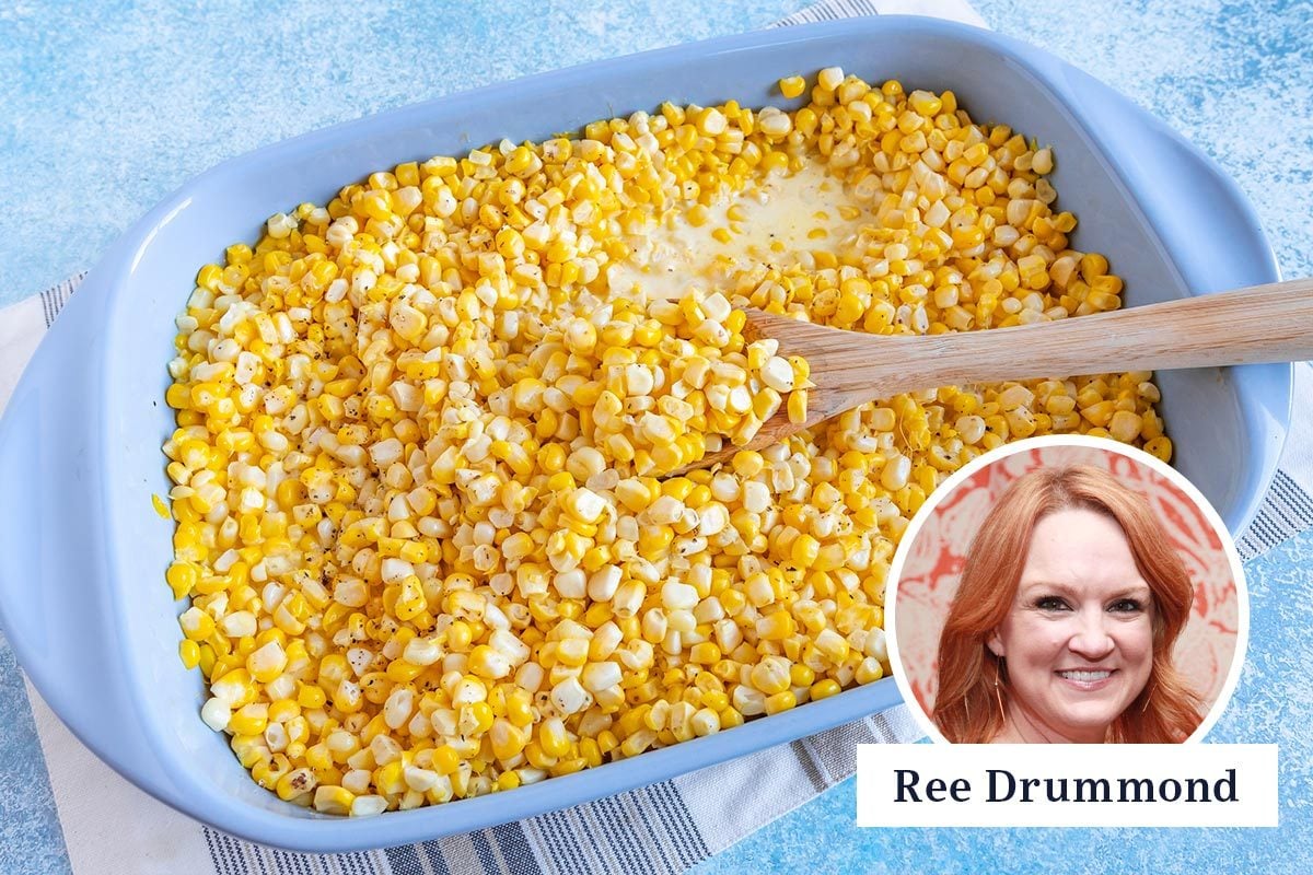 corn casserole in a blue serving dish with a wooden spoon