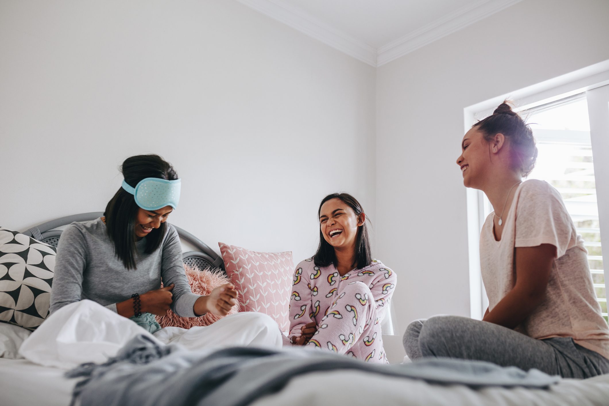 Girls talking to each other sitting on bed