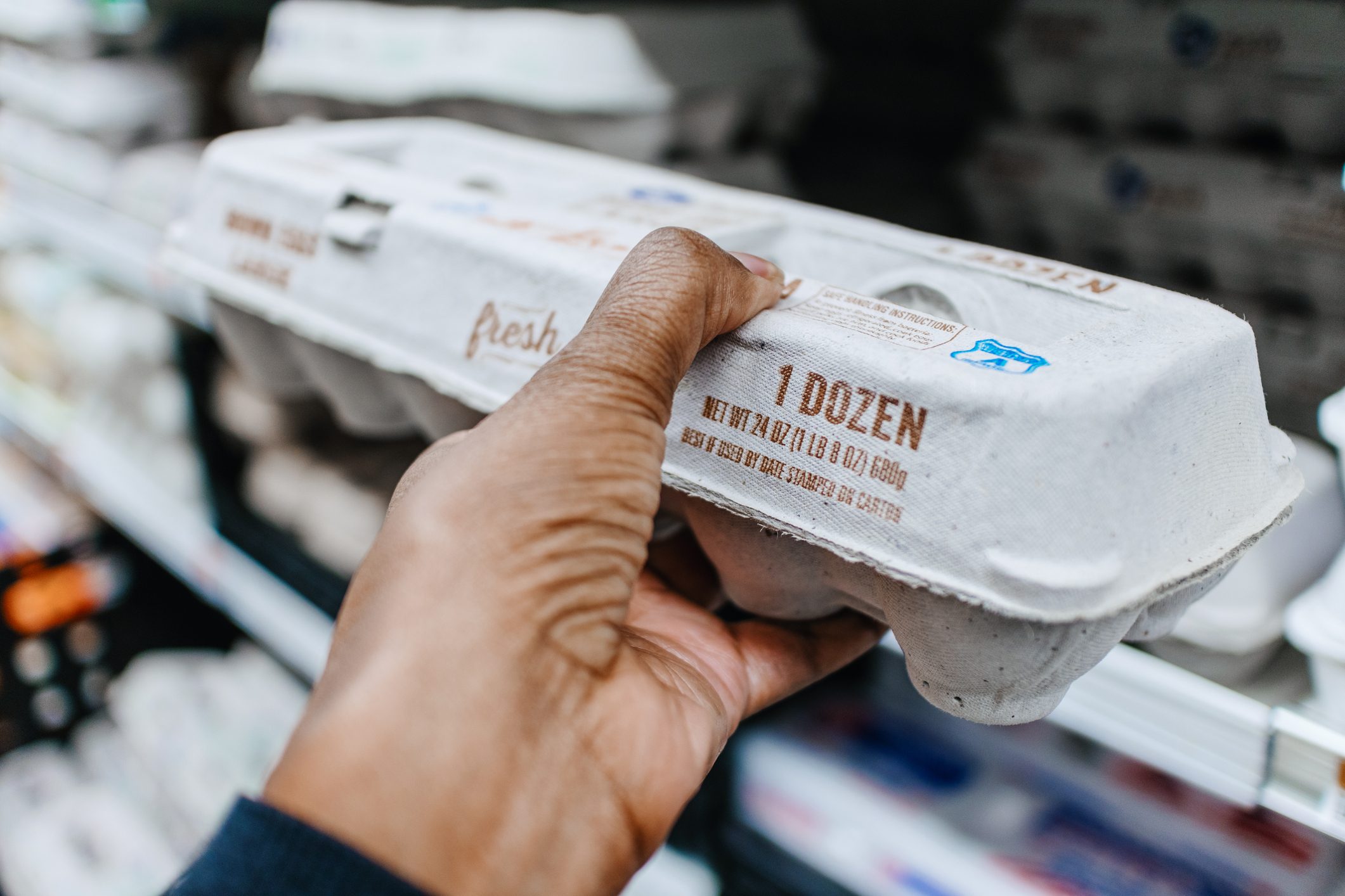 Woman Picks Up Carton of Eggs at Supermarket