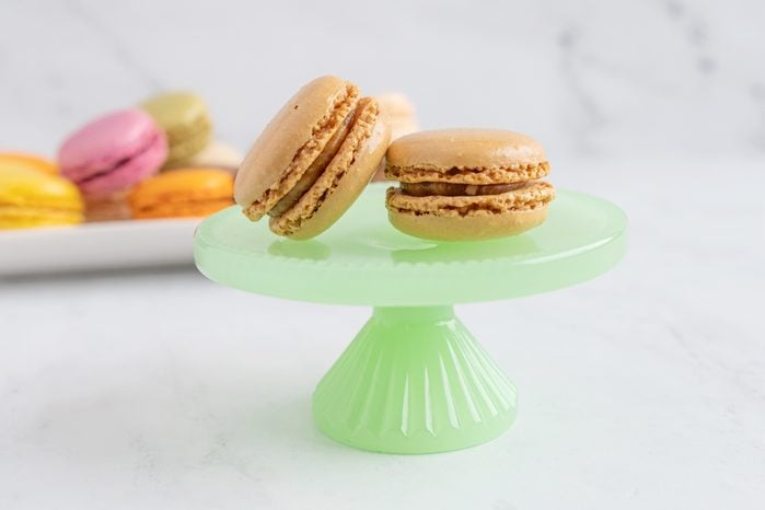 Salted Caramel macaroon on a green plate with a stand