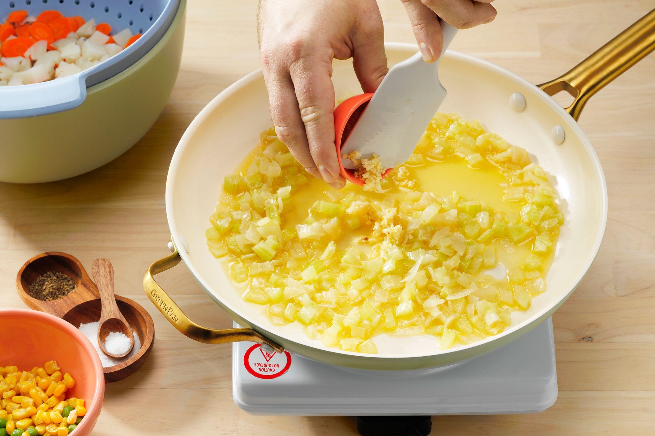 Vegan Potpie Showing Garlic Being Added To Potato Carrot Mixture.