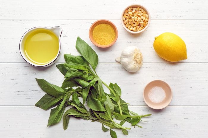 Vegan Pesto ingredients laid out on a white wood surface