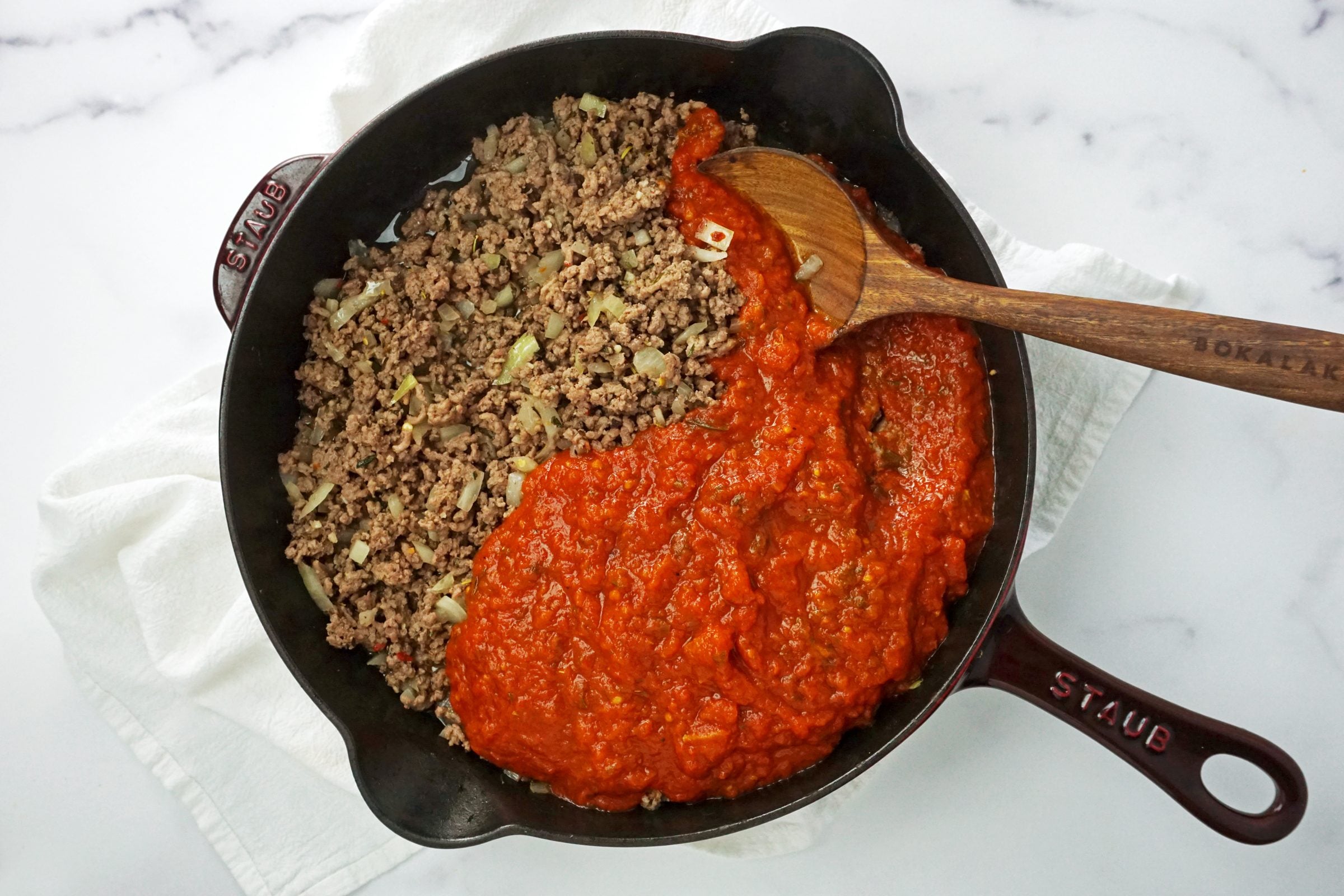 red sauce and cooked beef in a cast iron skillet