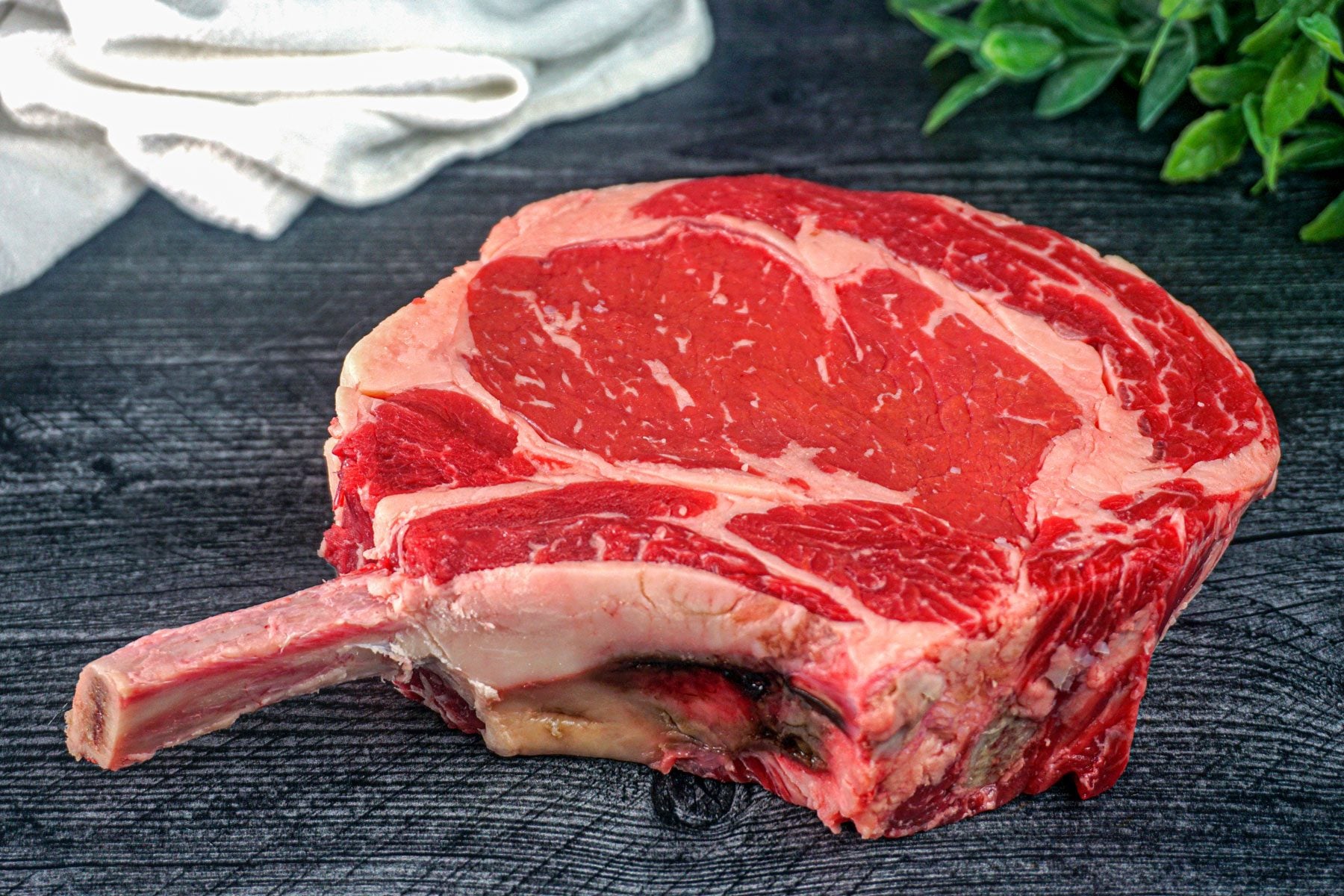 Raw Cowboy steaks on a kitchen table