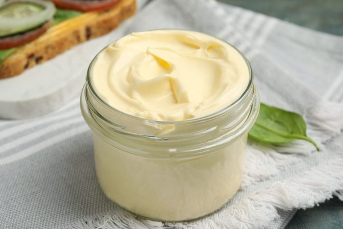 ar of delicious mayonnaise and napkin on light blue wooden table