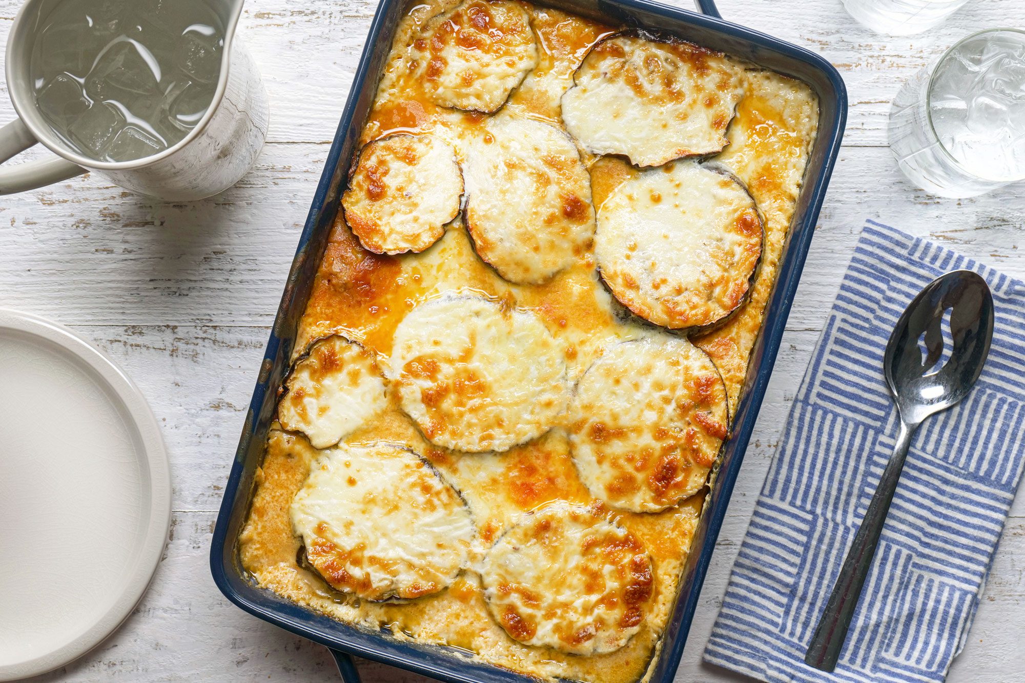 Moussaka served with luscious béchamel sauce in serving plate