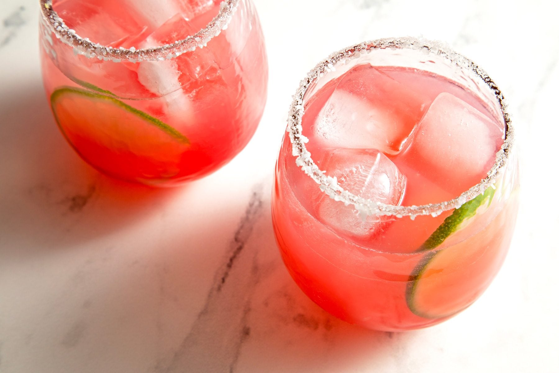 Two glass of pear margaritas garnished with lime wedges
